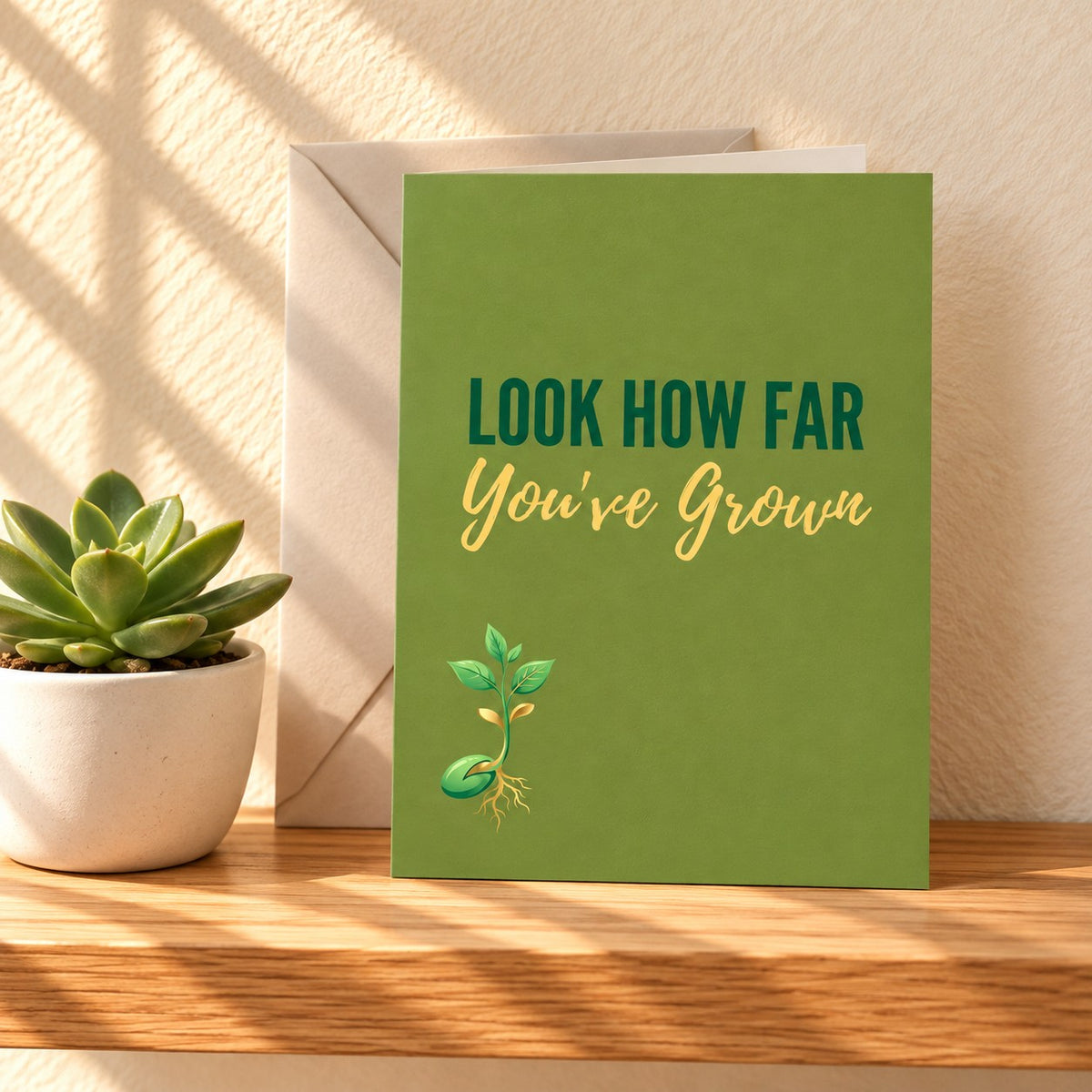 Look How Far You've Grown card in leaf green with a small sprouting seedling, standing on a light oak shelf beside a succulent